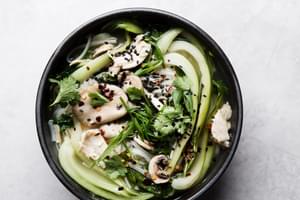 large black bowl with leftover turkey soup made with shallots, garlic, ginger, chicken stock, bok choy and rice noodles