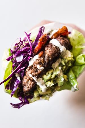 Close up of a hand holding a Low Carb Bacon Burger With Jalapeño Mayo