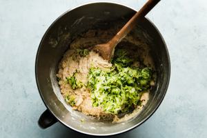 moms zucchini bread muffin batter with grated zucchini in a mixing bowl
