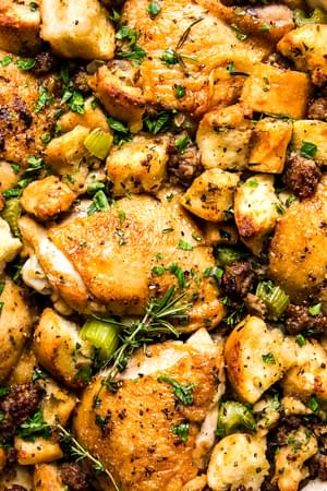 close up of chicken, sausage and stuffing casserole topped with fresh herbs