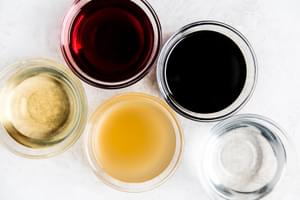 small bowls of vinegars, balsamic, white , red wine, apple cider and rice vinegar.