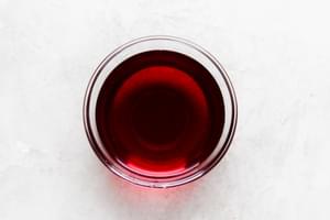 A glass bowl of red wine vinegar.