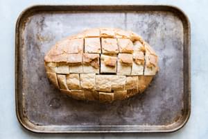 country loaf of bread on a baking sheet sliced into cubes