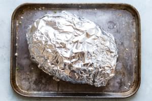 crusty bread filled with cheese and for garlic pull apart bread wrapped in foil on a baking sheet