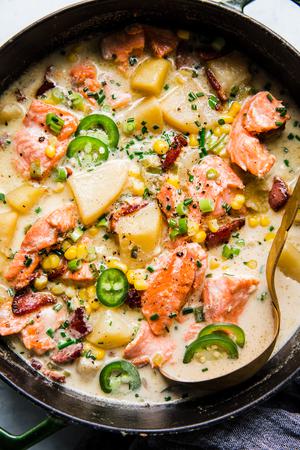 a large pot of salmon chowder with bacon, corn and potatoes