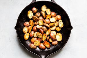 baby red potatoes in a cast iron skillet with herbs.