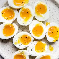 speckled plate topped with six minute eggs cut in half sprinkled with salt and freshly ground pepper