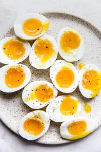 speckled plate topped with six minute eggs cut in half sprinkled with salt and freshly ground pepper