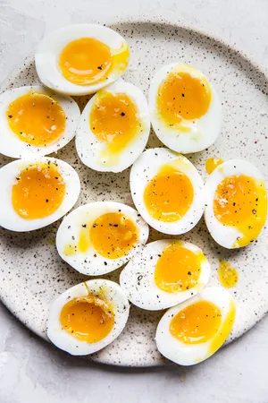 speckled plate topped with six minute eggs cut in half sprinkled with salt and freshly ground pepper
