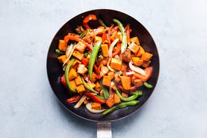 Sweet Potato in a pan with red and green bell peppers and onion