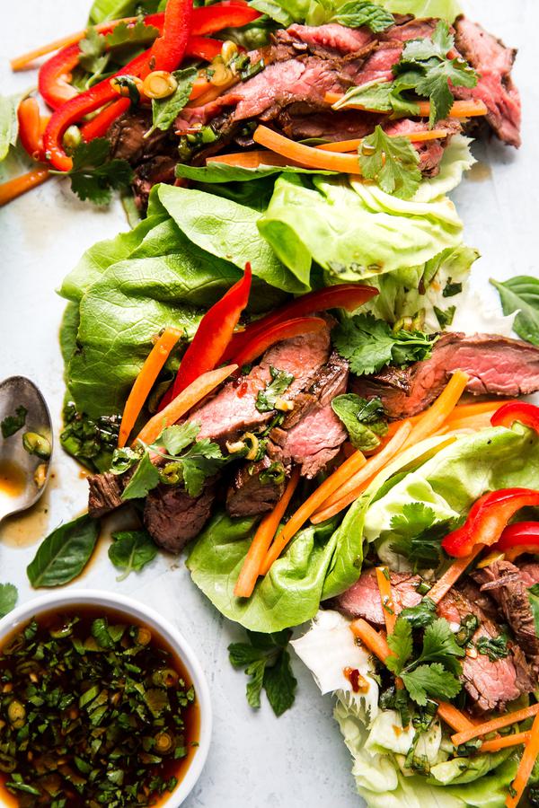 lettuce cups with Thai style steak sliced up, bell peppers, carrots and sauce inside