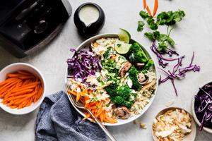 the base of a blender, a bowl of carrots, and a green curry rice bowl with a spoon