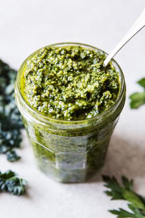 walnut kale vegan pesto in a glass jar with a spoon