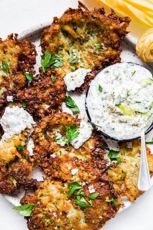 Mediterranean Style Zucchini Fritters With Tzatziki Dipping Sauce on a plater