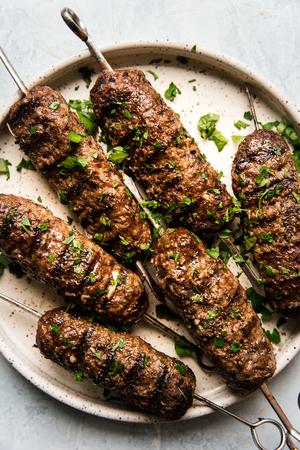 6 beef kofta skewers on a plate with parsley