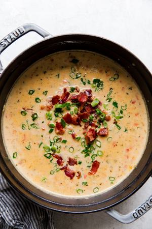 beer cheese soup with bacon, jalapeño, and green onions in a soup pot
