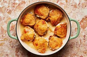 bone-in, skin-on chicken thighs seasoned with salt being browned in a skillet with olive oil