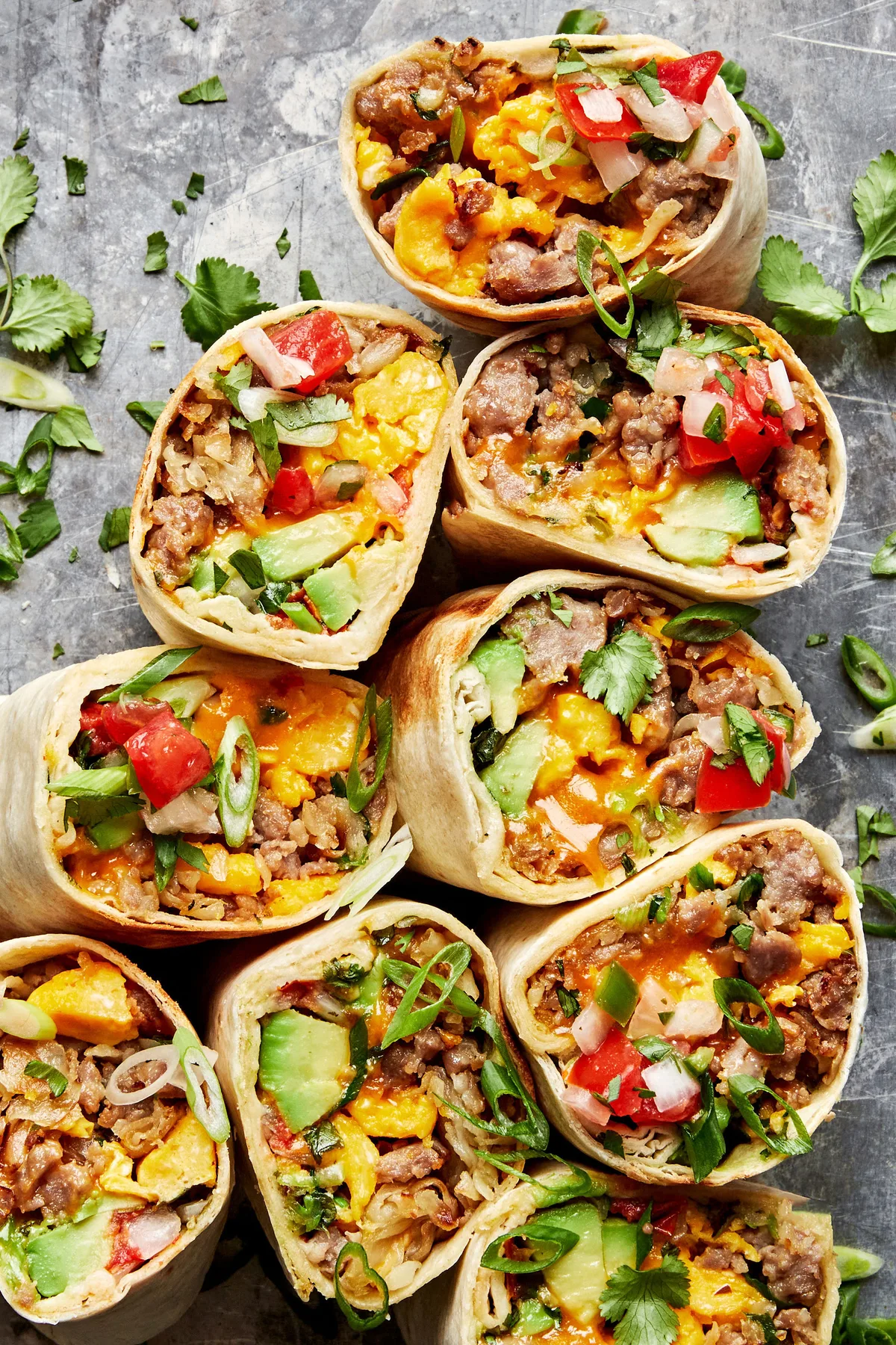 homemade potato, egg and sausage breakfast burritos sliced in half in a list of make-ahead breakfast recipes