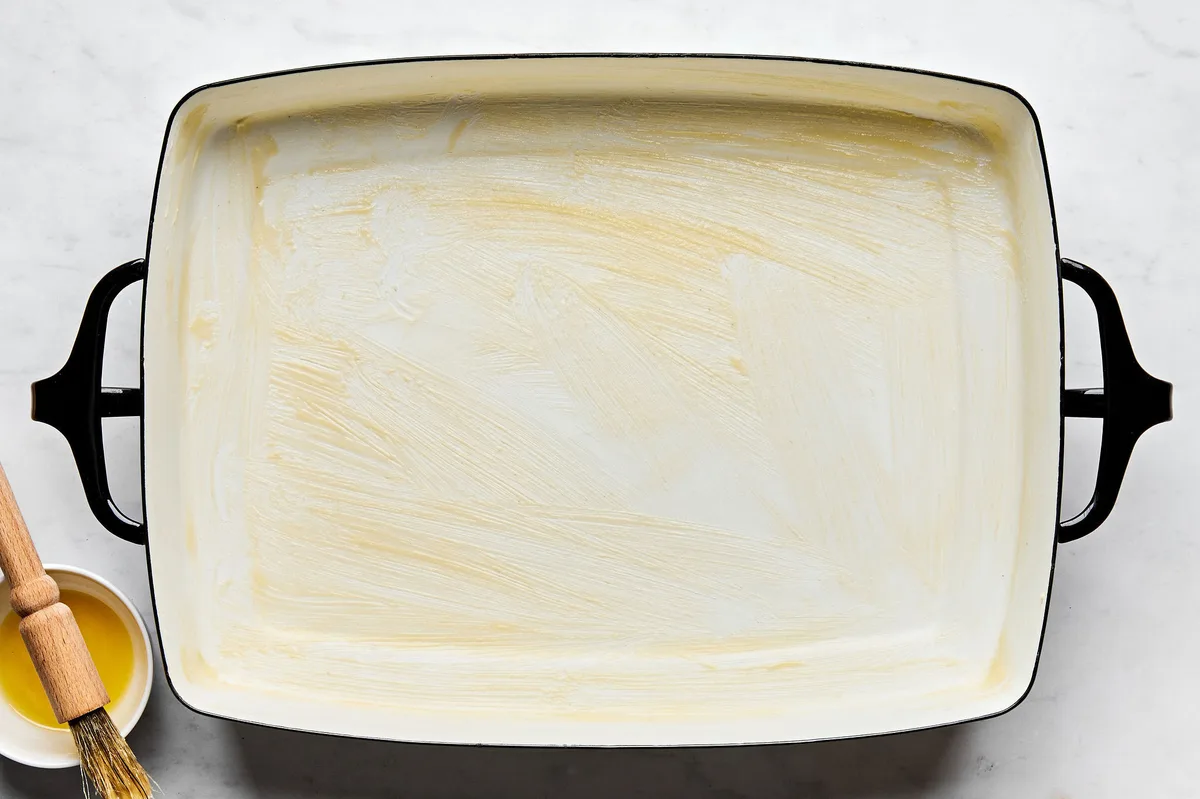 a greased casserole dish prepared for a sausage, egg and cheese breakfast casserole