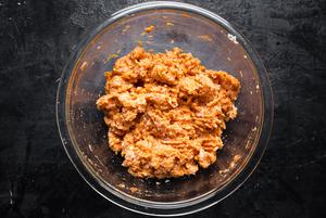 ground chicken, grated onions, an egg, panko, buffalo sauce, salt pepper and spices mixed in a bowl for buffalo meatballs