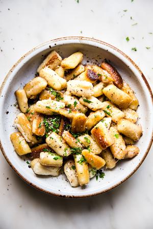 cauliflower gnocchi in a bowl with parmesan, butter and parsley