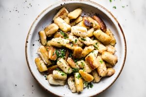 cauliflower gnocchi in a bowl with parmesan, butter and parsley