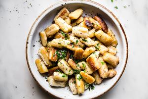 cauliflower gnocchi in a bowl with parmesan, butter and parsley