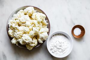 cauliflower, flour and salt in bowls on the counter