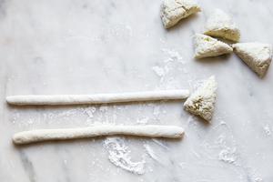 raw cauliflower gnocchi rolled into thin pieces on the counter