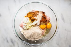 ground meat, bread crumbs, eggs and spices in a bowl for chicken shawarma meatballs