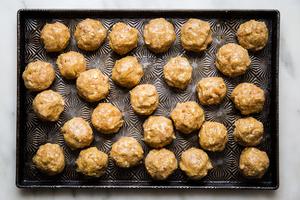 raw chicken shawarma meatballs shown on a baking sheet