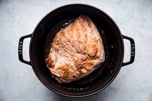 pork shoulder browned in a large black pot