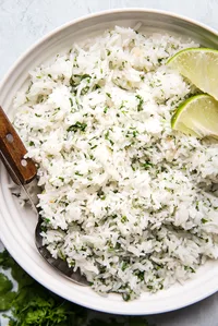 homemade cilantro lime rice in a bowl with a wooden spoon