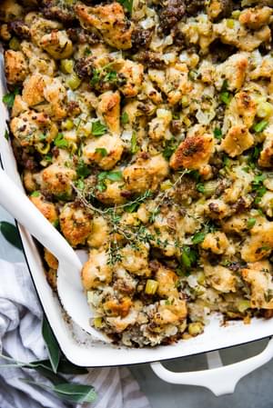 classic sausage stuffing in a baking dish with a serving spoon