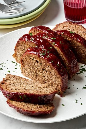 Sliced meatloaf on a plate topped with a brown sugar and ketchup glaze, a classic comfort food dinner recipe.