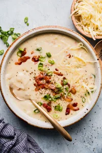 creamy potato soup made with bacon, leeks and cream topped with extra bacon green onions and white cheddar cheese