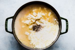 leeks, butter, chicken stock, potatoes, milk, salt and pepper cooking in a soup pot