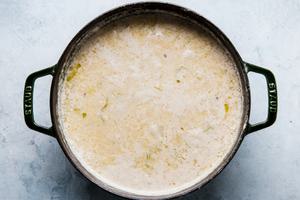 leeks, butter, chicken stock, potatoes, milk, salt and pepper cooking in a soup pot