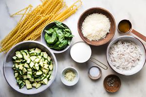 zucchini in a bowl, pasta noodles, cream, salt, parmesan, pepper, basil and garlic ingredients