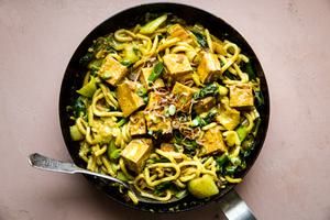 Crispy Tofu with Creamy Curry Udon Noodles in a sauce pan with fried shallots, baby bok choy, and green onions