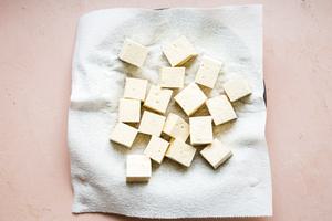 raw tofu draining on a kitchen towel