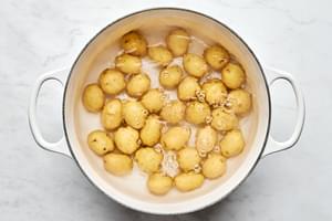 baby yukon gold potatoes being boiled in a pot of salted water
