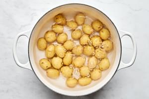 baby yukon gold potatoes being boiled in a pot of salted water