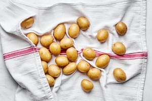 boiled potatoes being thoroughly dried on a kitchen towel