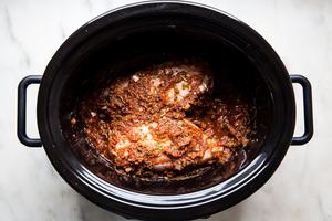 raw chicken breasts mixed with salsa and taco seasoning in a crock pot