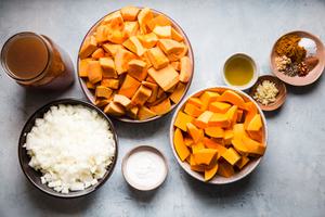 ingredients for curried pumpkin soup including butternut squash, pumpkin, spices, chicken broth, onions and coconut milk