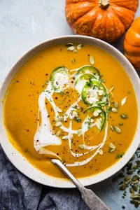 Curried pumpkin soup topped with pumpkin seeds, slivered jalapenos, and drizzled with coconut milk