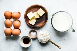 6 eggs, 4 tablespoons salted butter, flour, whole milk, salt and vanilla in prep bowls for Dutch Baby Pancakes