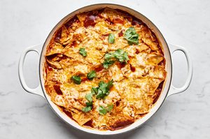 Skillet chicken enchiladas topped with melted cheese and fresh cilantro, a easy weeknight dinner