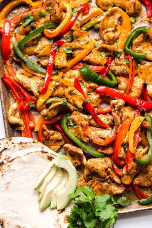 freezer chicken fajita meal on a sheet pan for dinner with tortillas and avocado and bell peppers